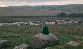 a man on a rock in the wilderness in the UK 