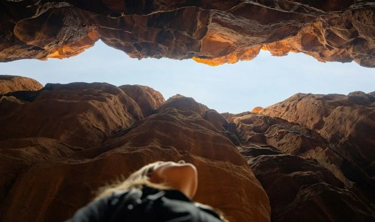 A woman looking up into a crack.