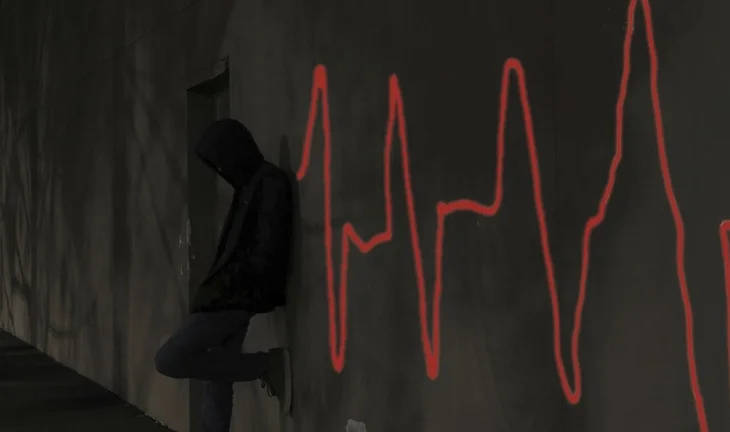 a hooded figure standing next to a pulse