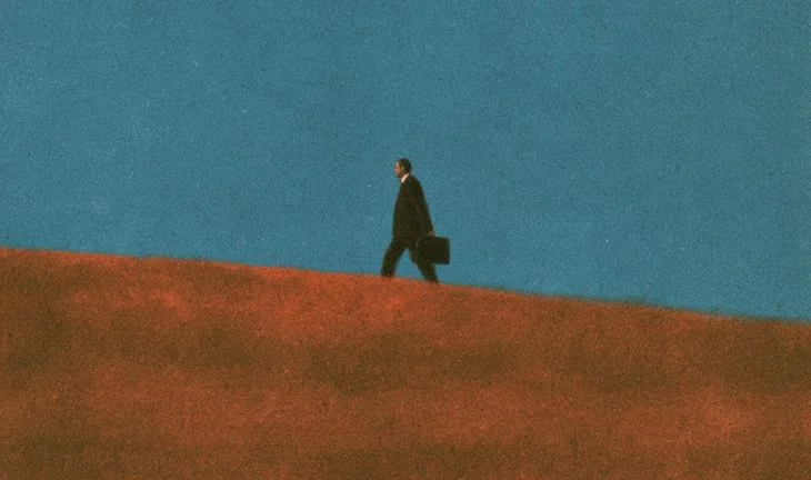 a banker walking uphill against a blue sky