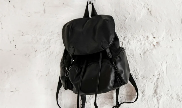 a black rucksack on a white wall 