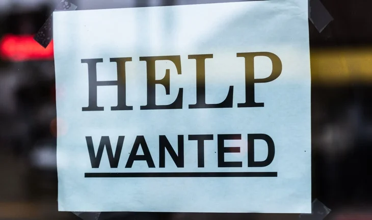 a sign that says help wanted