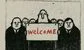 a banker holding a sign that says welcome in red